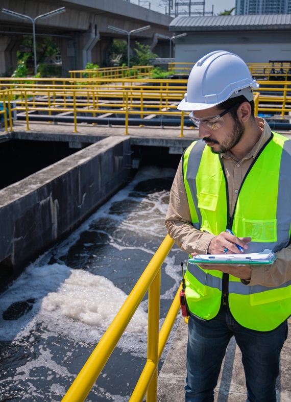 engineer take water from wastewater treatment pond to check the quality of the water. after going through the wastewater treatment process